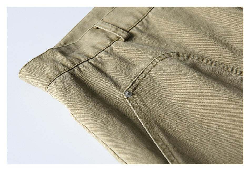 Close-up of khaki pants showing a belt loop, waistband stitching, and curved front pocket.