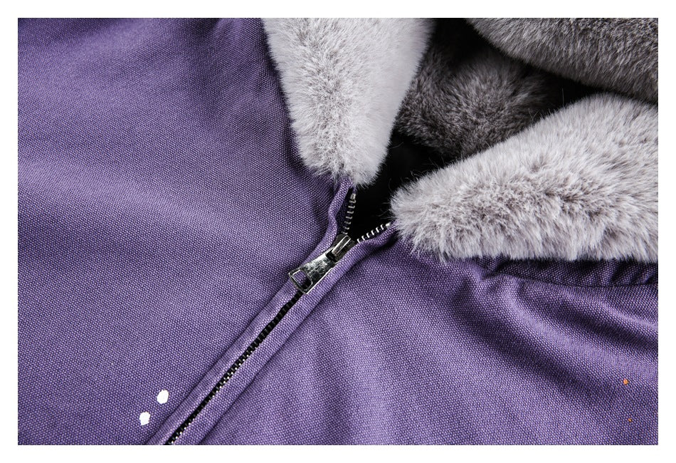 Close-up of the purple jacket's black front zipper, gray fur trim, and small white and orange paint marks.