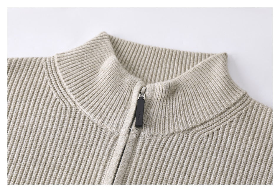 Close-up of a cream ribbed knit sweater's tall collar and front zipper.