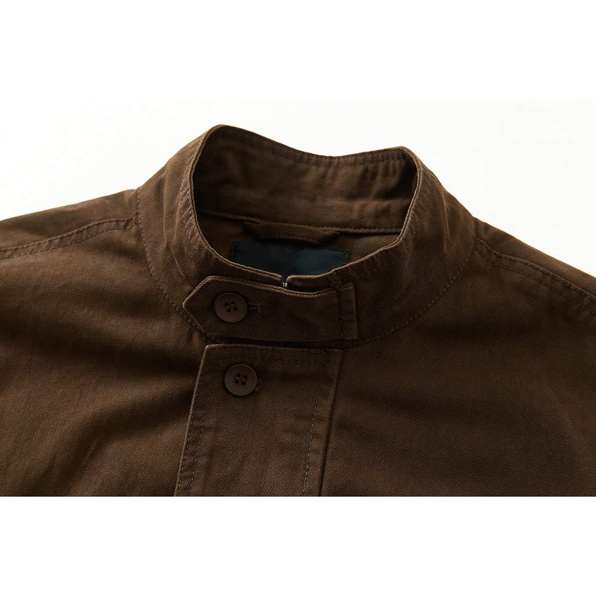 Close-up of a dark brown jacket's stand collar, buttoned throat tab, and front buttons.
