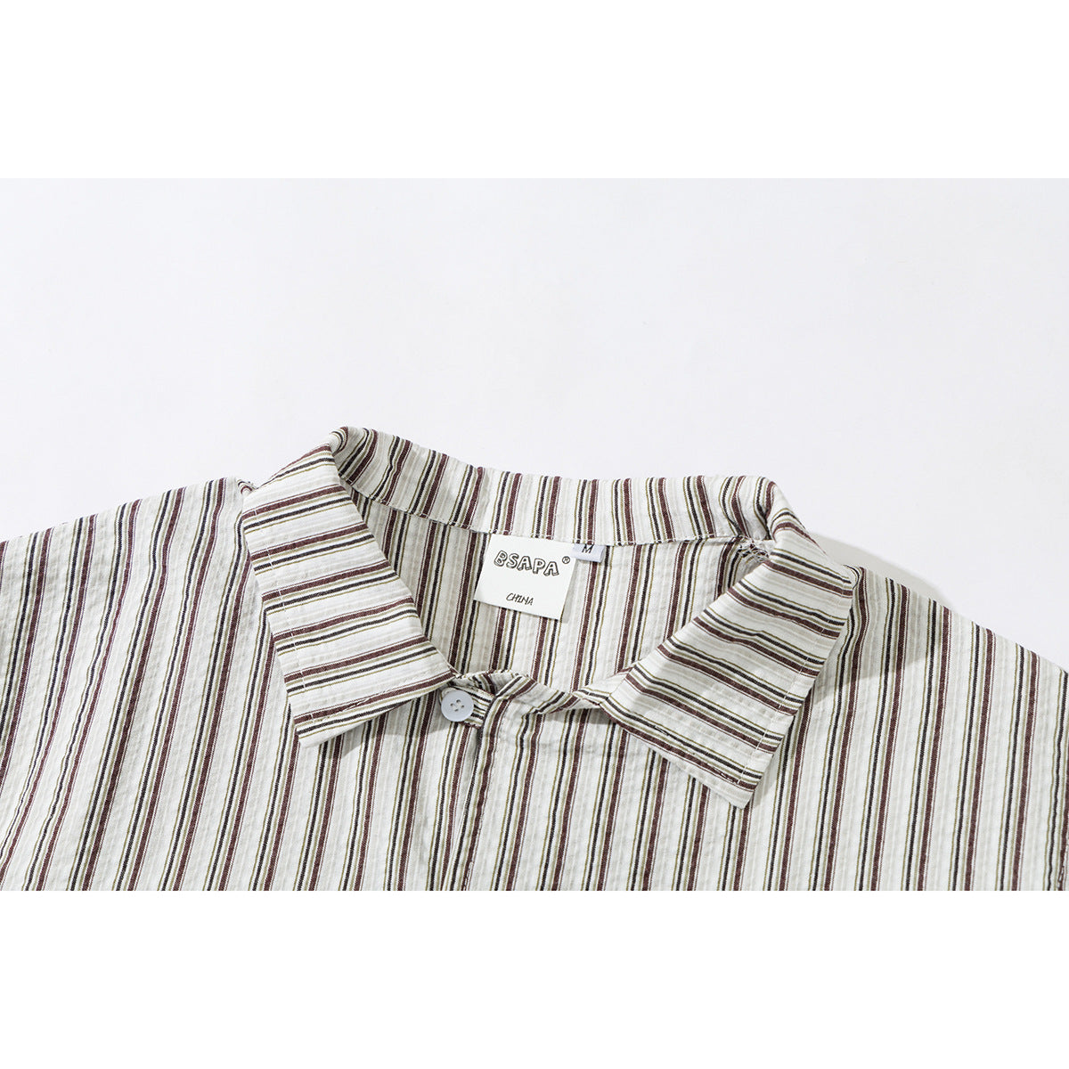 Close-up of a cream striped shirt collar, top button, and sewn neck label.