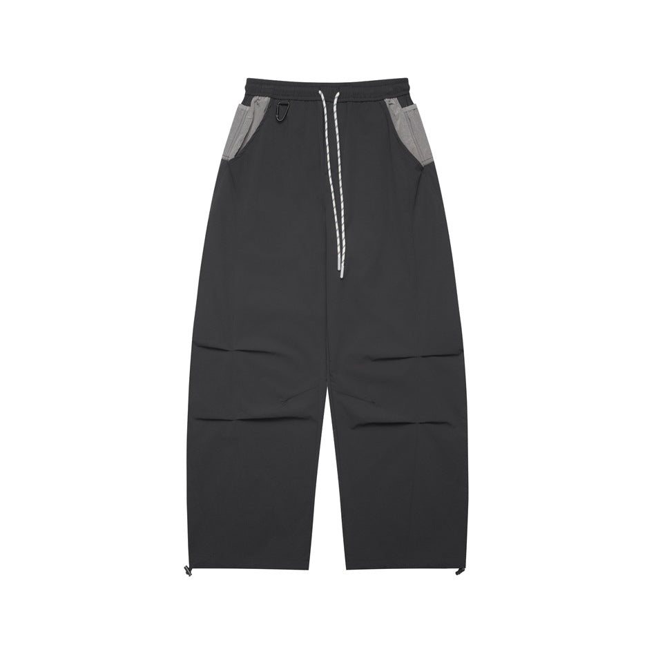 Dark gray wide-leg drawstring pants with light gray pocket panels and knee pleats, flat front view