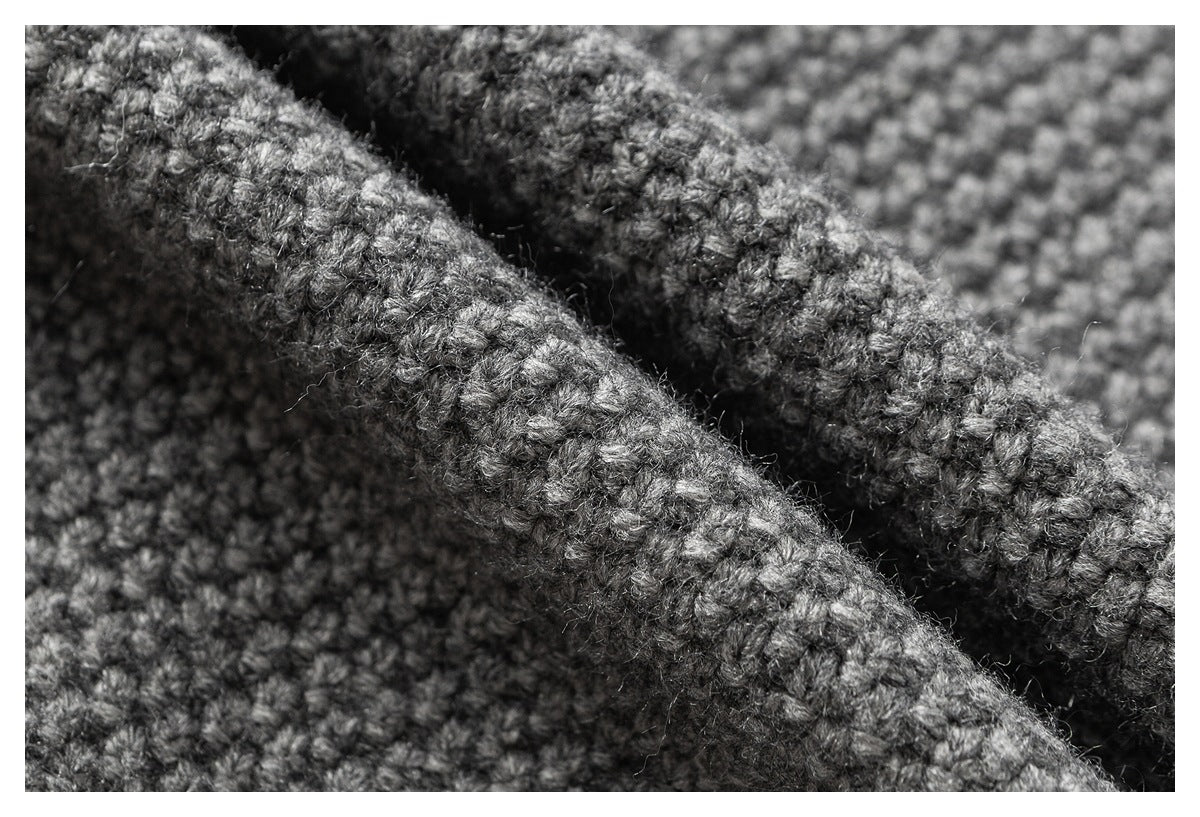 Macro close-up showing the chunky, mottled stitches of gray knit fabric.