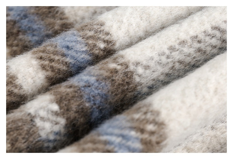 Extreme close-up of fuzzy plaid fabric in cream, taupe, brown, and muted blue.