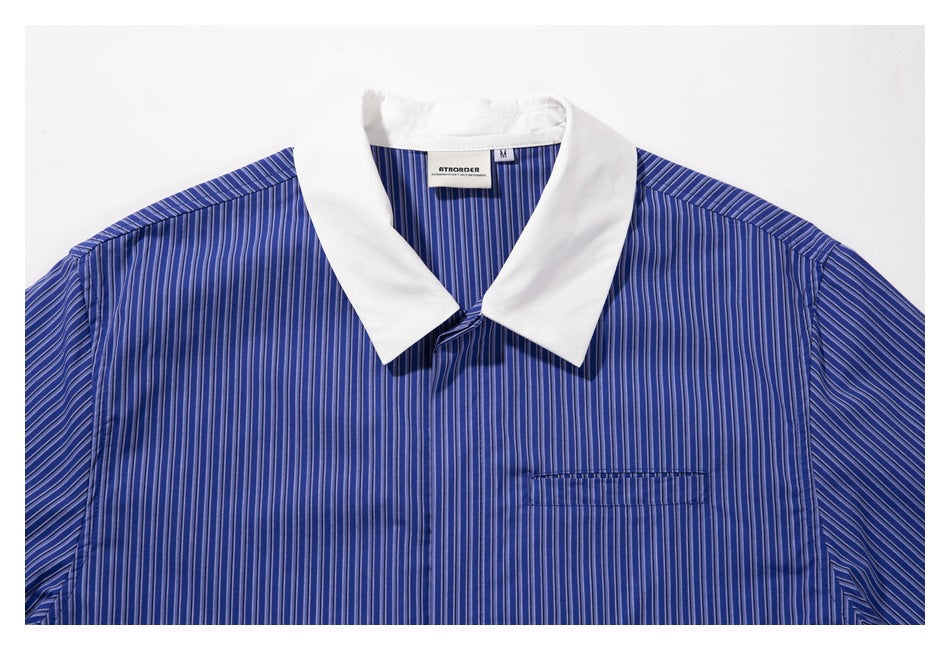 Upper front of a blue vertically striped shirt with a broad white collar and a single chest pocket.