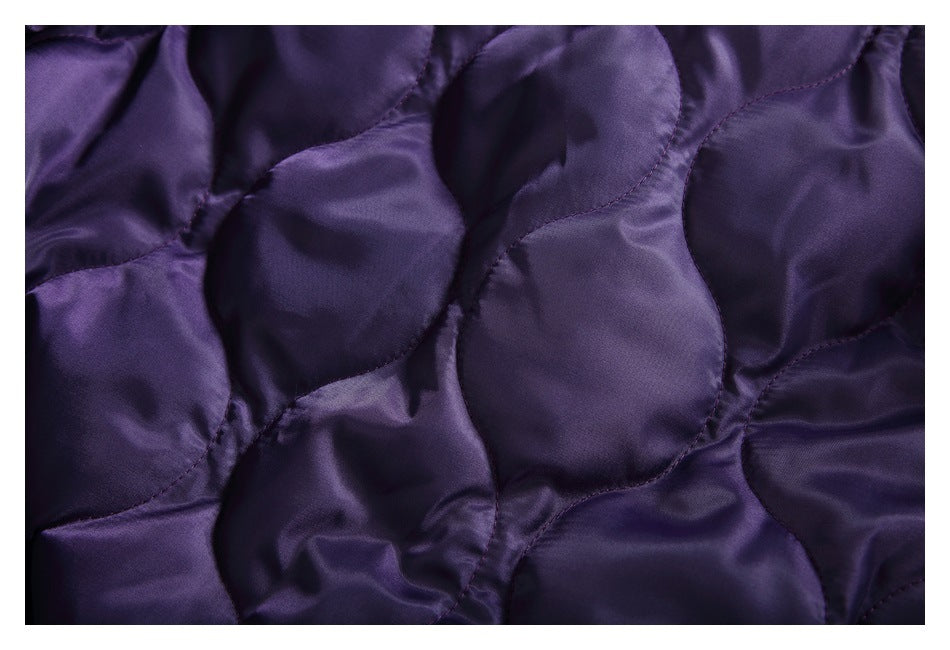 Close-up of the dark purple jacket's quilted lining with curved stitched panels.