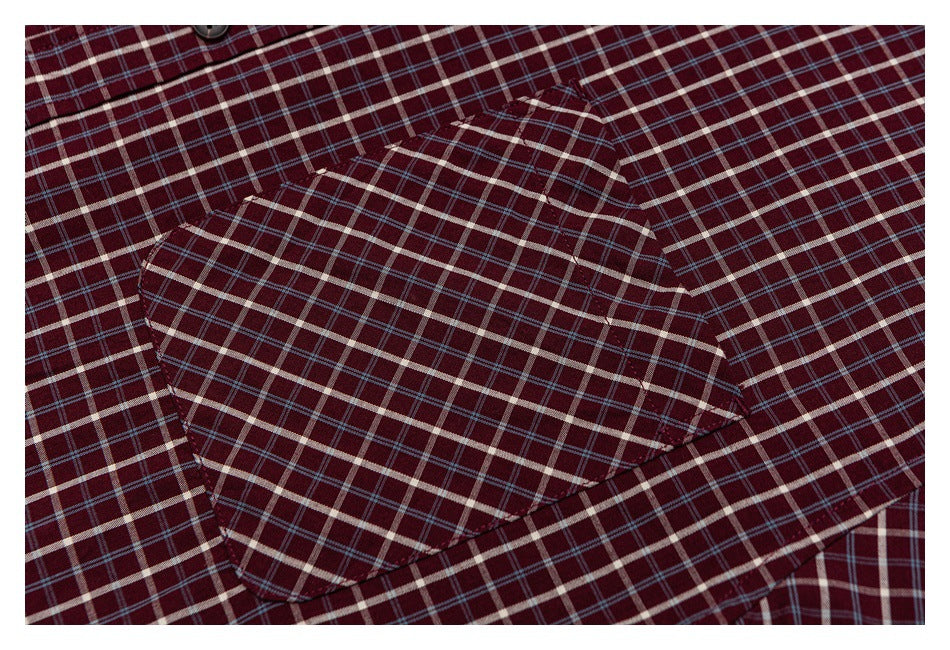 Close-up of a chest pocket on a burgundy shirt, patterned in cream and blue plaid.