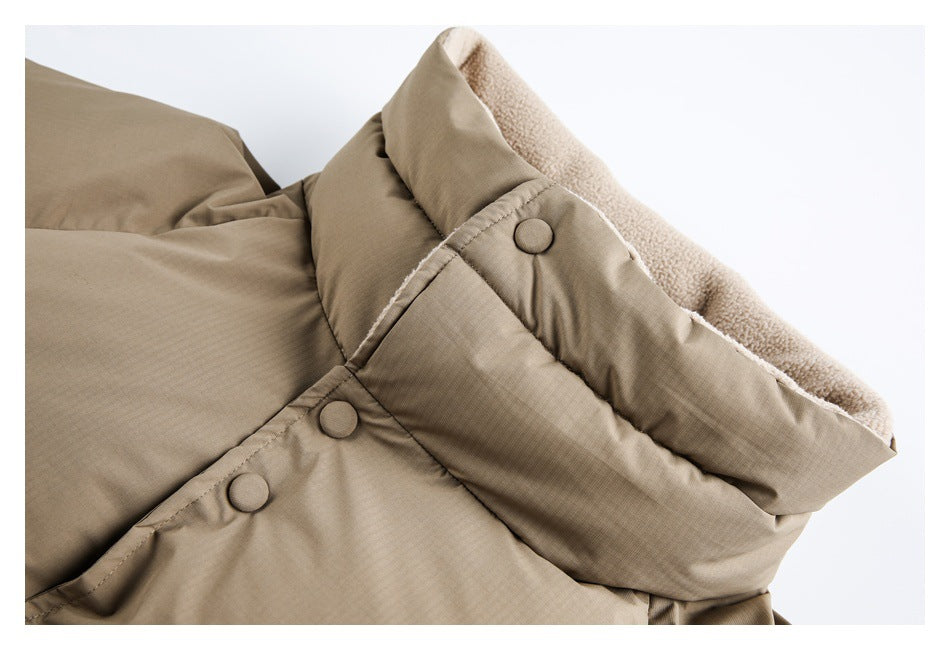 Beige padded garment close-up showing a fleece-lined edge and fabric-covered snap buttons.