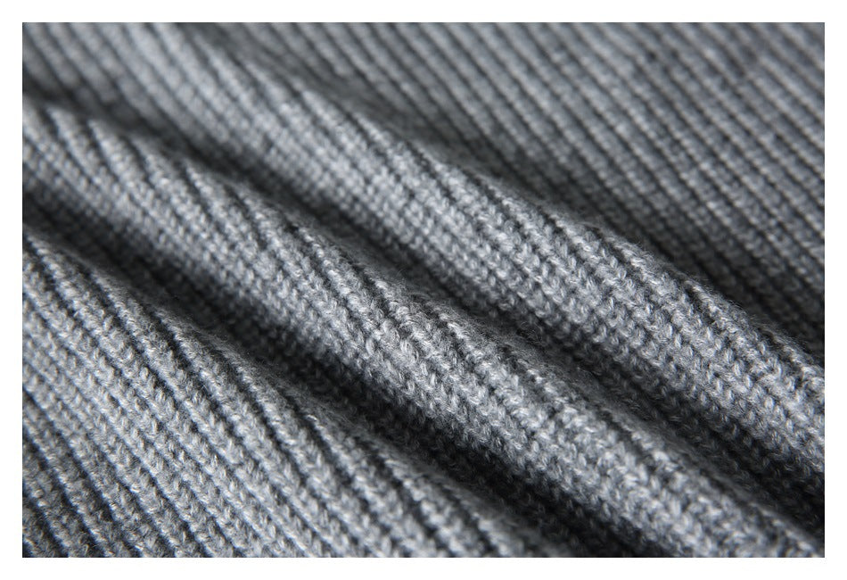 Macro view of the gray sweater's rib-knit texture and stitches.