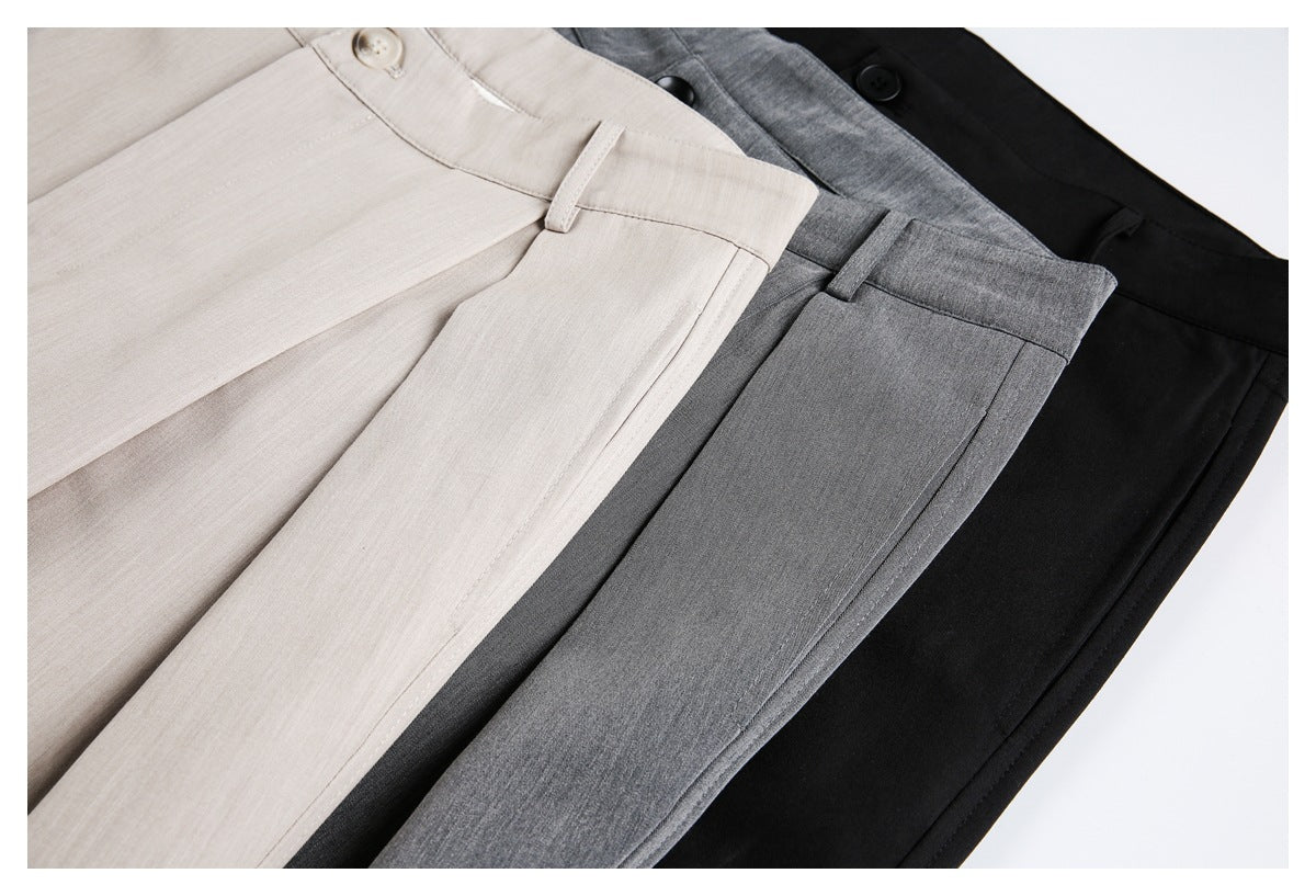 Beige, gray, and black trousers arranged together in a close-up of their fabric and front panels.