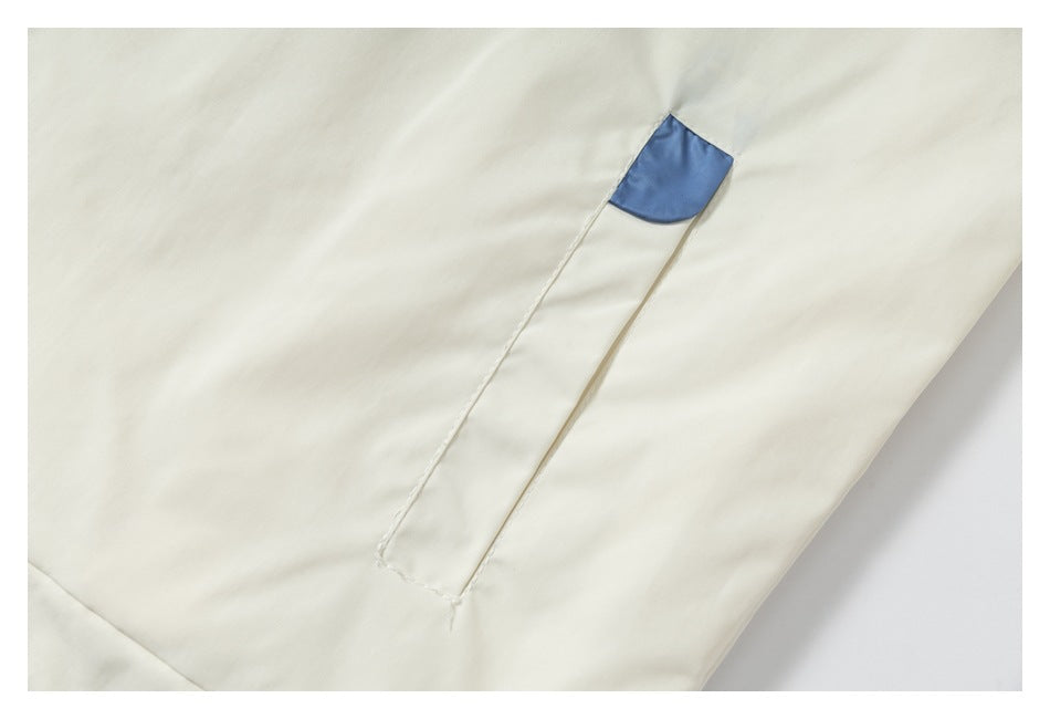 Close-up of an ivory jacket pocket with a pale blue accent at the opening.