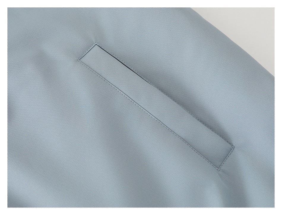 Close-up of a narrow welt pocket on the light blue-gray jacket.