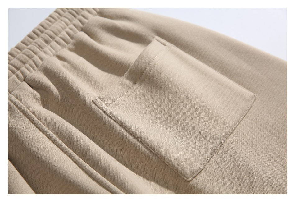 Close-up of beige pants showing an elastic waistband and a large stitched patch pocket.