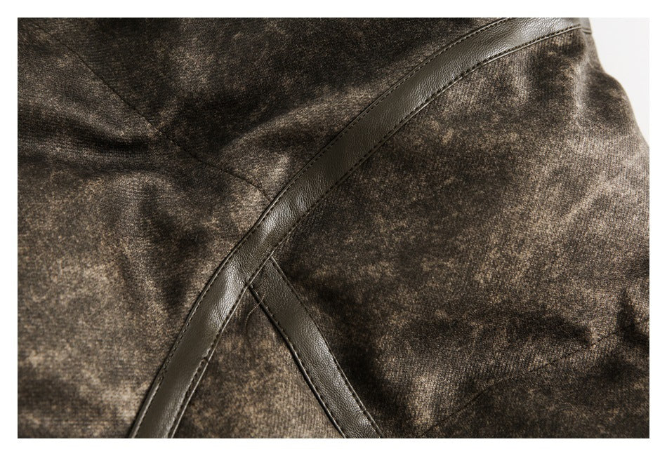 Close-up of curved dark leather-like trim and stitching on mottled brown jacket fabric.