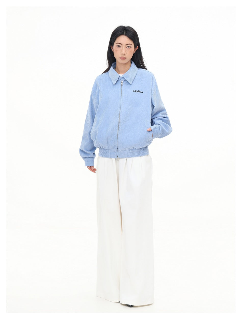 Full-length front view of a model wearing a light blue collared zip jacket and wide-leg white trousers.
