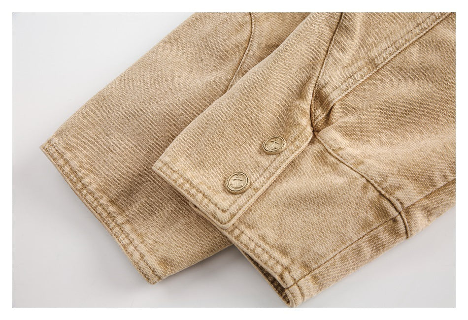 Close-up of a tan garment cuff with two round buttons and visible topstitching.