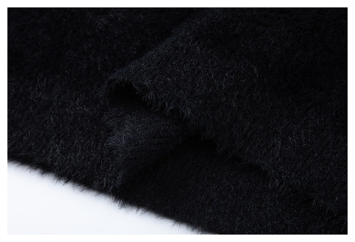 Close-up of black fuzzy fabric showing a folded seam or edge.