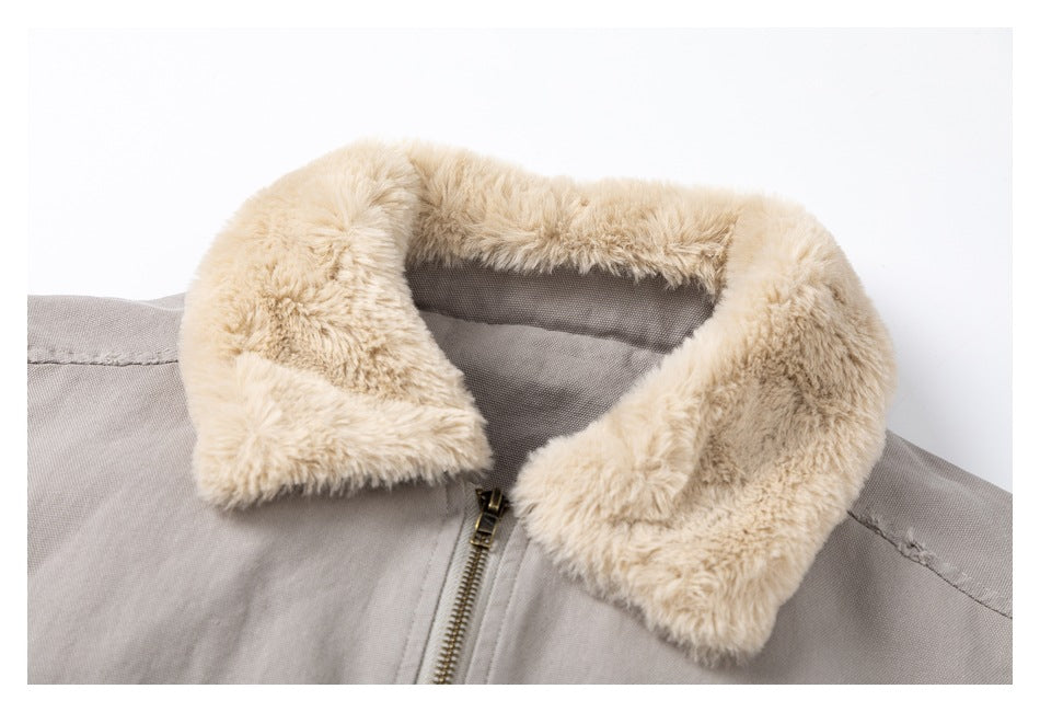 Close-up of the light gray bomber jacket's plush cream collar and front zipper.