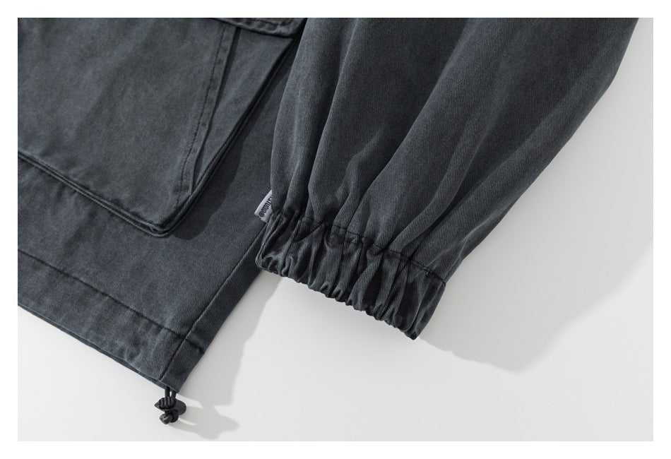 Close-up of a charcoal jacket's gathered elastic cuff and adjustable hem drawcord.