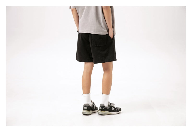 Back view of a model wearing black shorts with a rear pocket.
