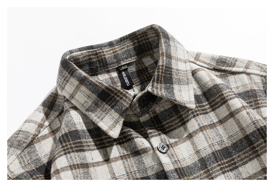 Close-up of a cream, gray, and brown plaid shirt collar and upper front with black buttons.