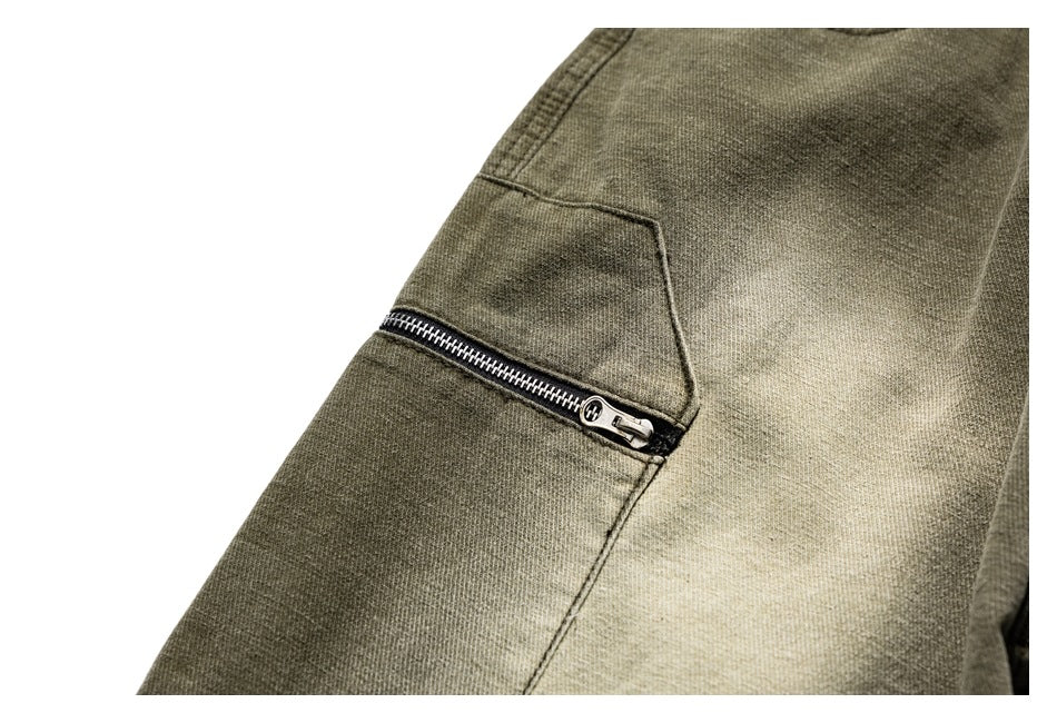 Close-up of an olive trouser leg with a horizontal black zipper pocket.