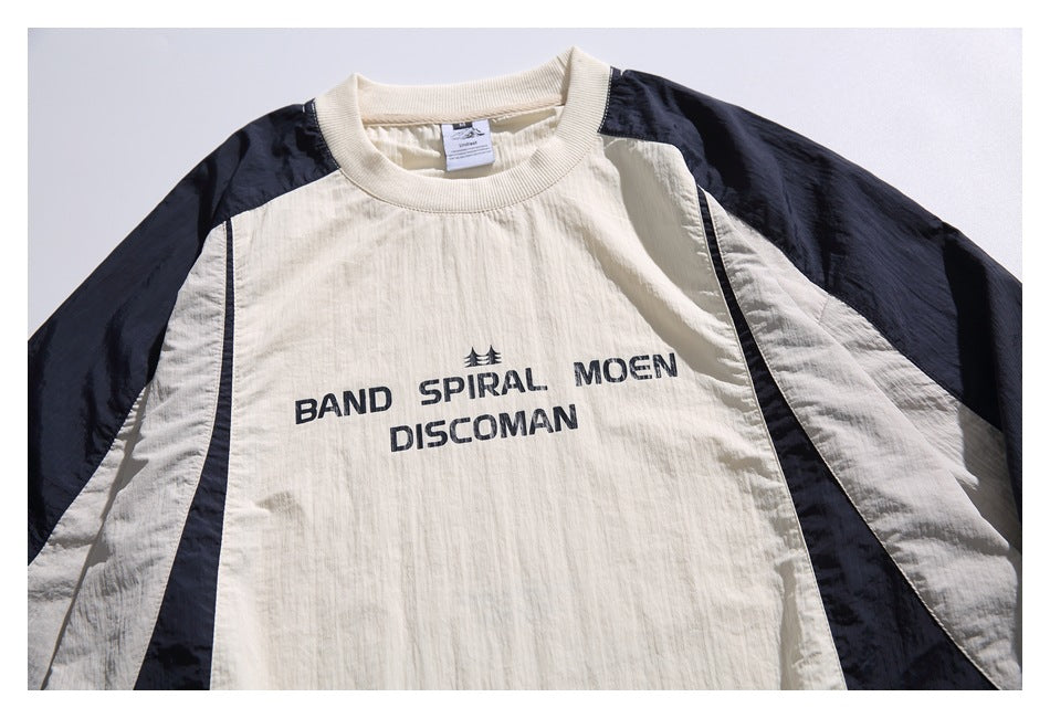 Front view of an ivory pullover with navy raglan sleeves and side panels, ribbed crew neck, and black chest lettering.