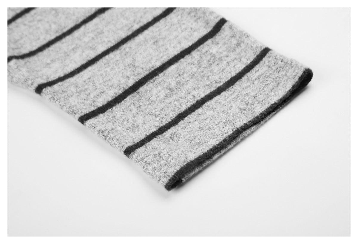 Close-up of gray knit fabric with black stripes and a folded edge.