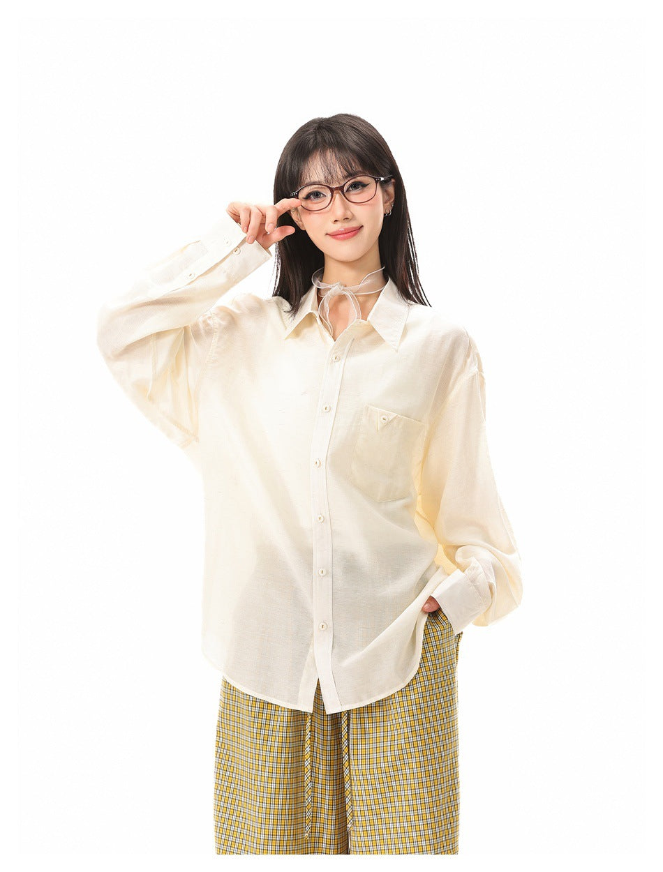 Model wearing an oversized ivory button-up shirt with a chest pocket and yellow plaid trousers.