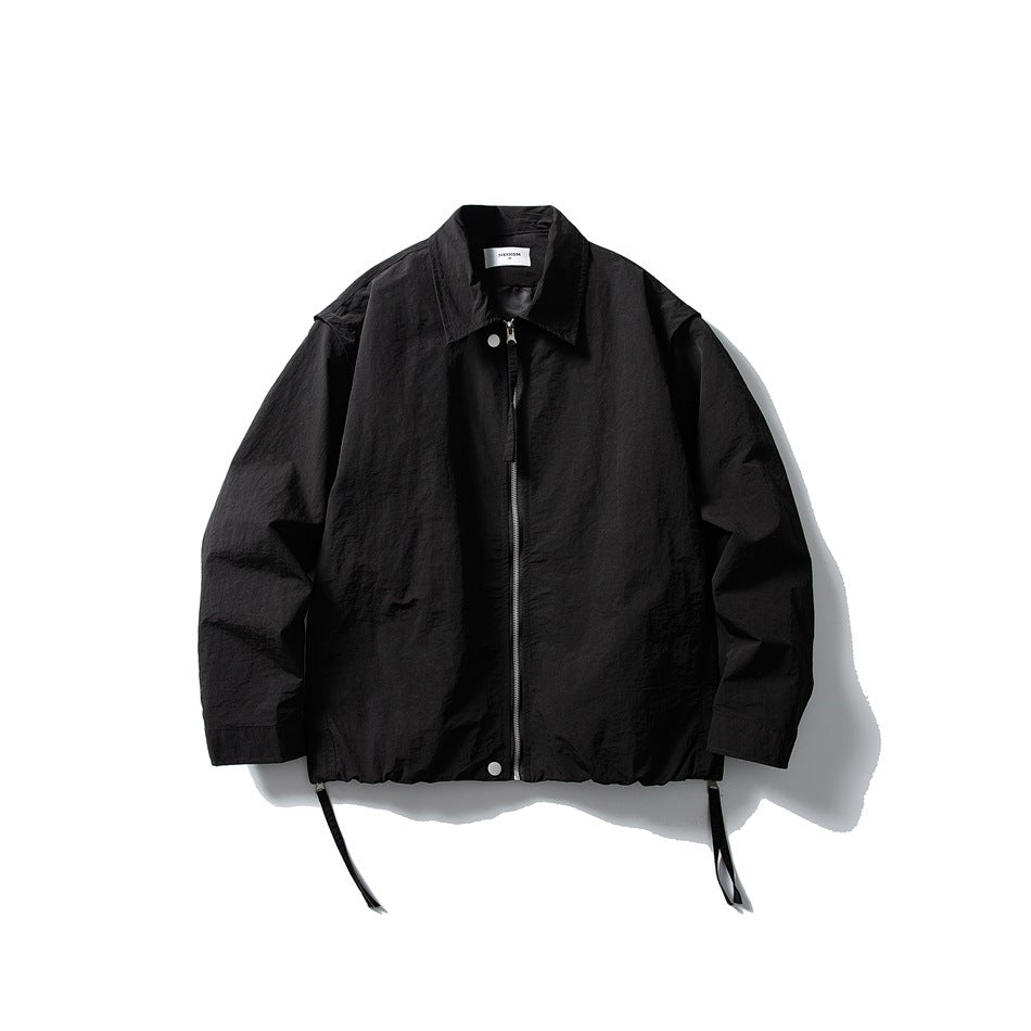 Black collared zip-front jacket flat lay with silver zipper, snap buttons, gathered hem and side straps