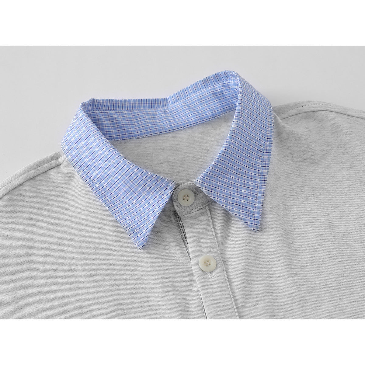 Close-up of a light gray polo shirt with a blue checked collar and a two-button placket.