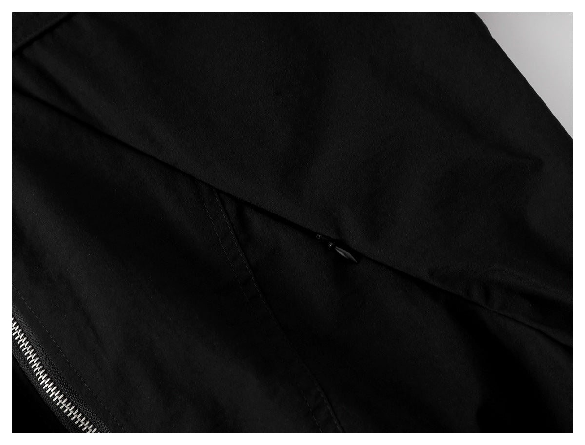 Close-up of a black jacket seam and concealed pocket opening beside the zipper.