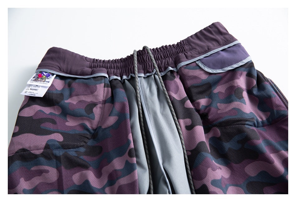 Front view of flat-laid shorts with purple camouflage panels, an elastic waistband, and a drawcord.