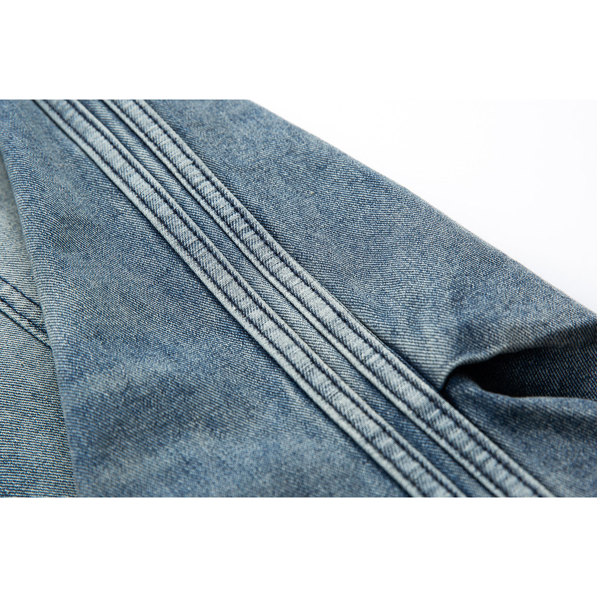 Close-up of blue denim fabric and parallel stitched seams.