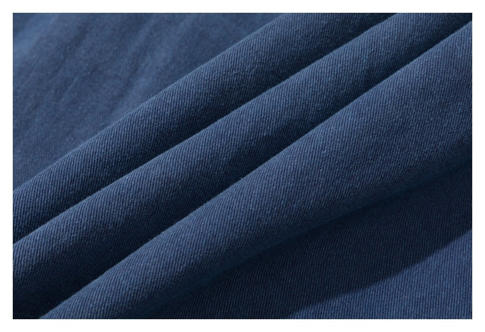 Macro view of dark blue fabric draped in folds, showing its textured weave.