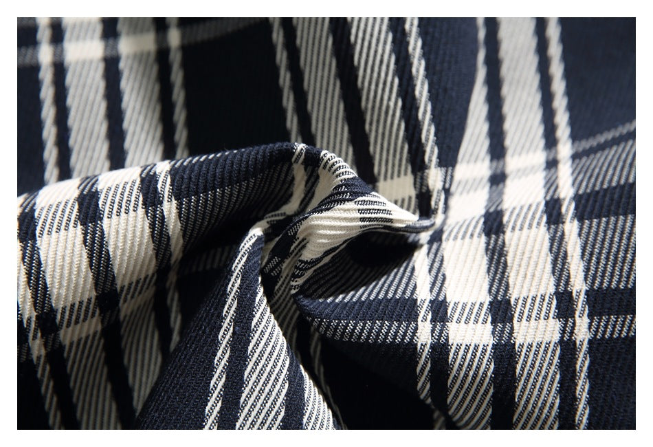 Close-up of the plaid fabric gathered into folds, showing its woven texture.