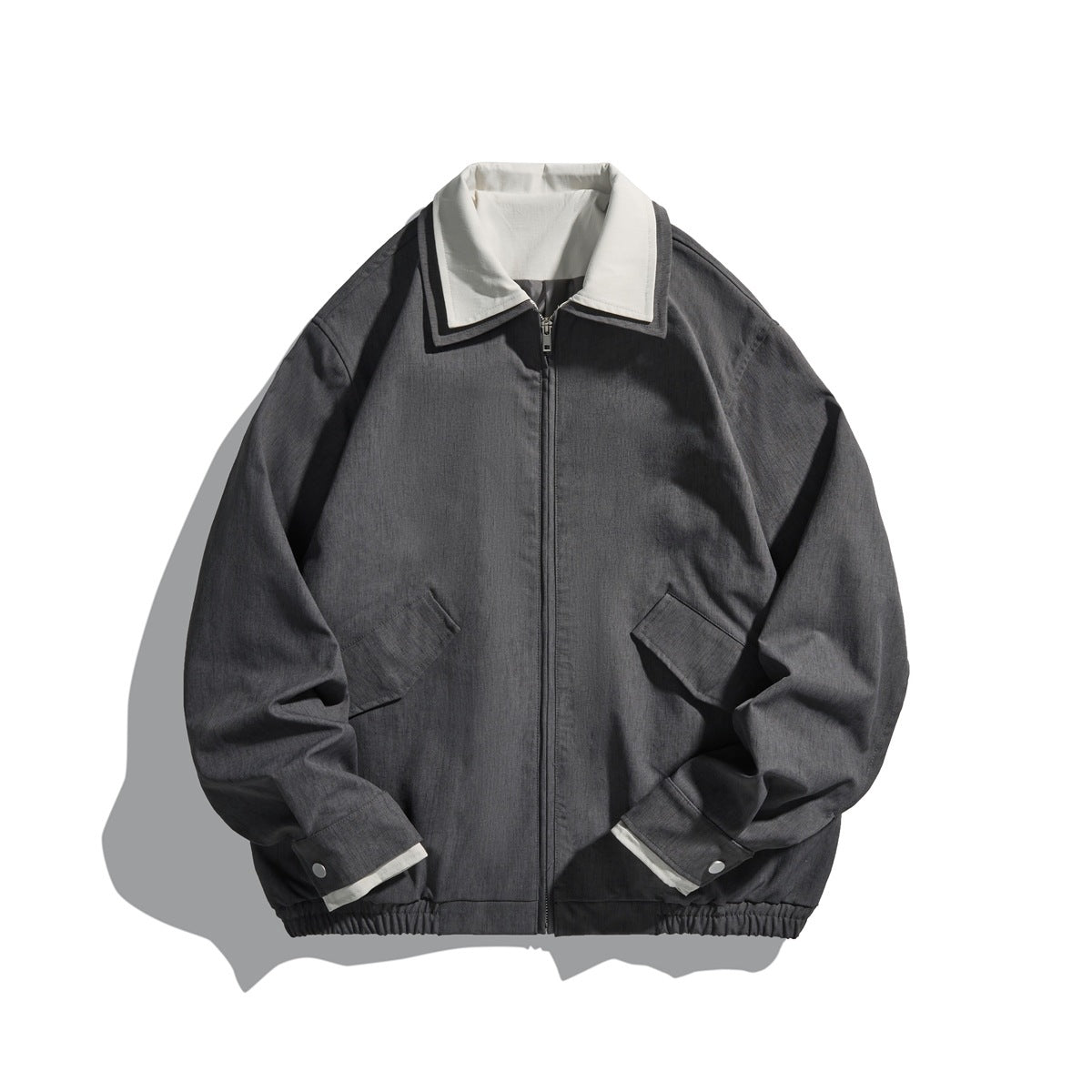 Medium gray zip-front collared jacket with off-white inner collar, flap pockets and elastic hem, flat lay