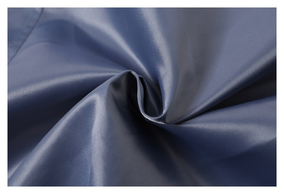Close-up of blue-gray fabric gathered into a fold, showing its surface and stitched edge.