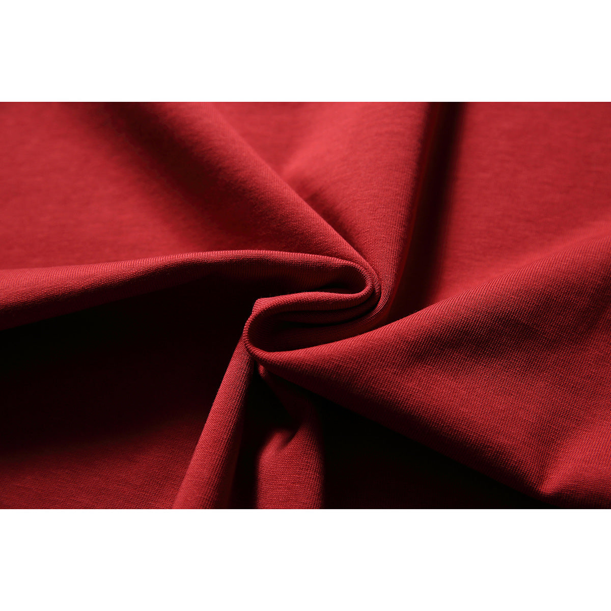 Close-up of red fabric gathered into folds, showing its surface texture.