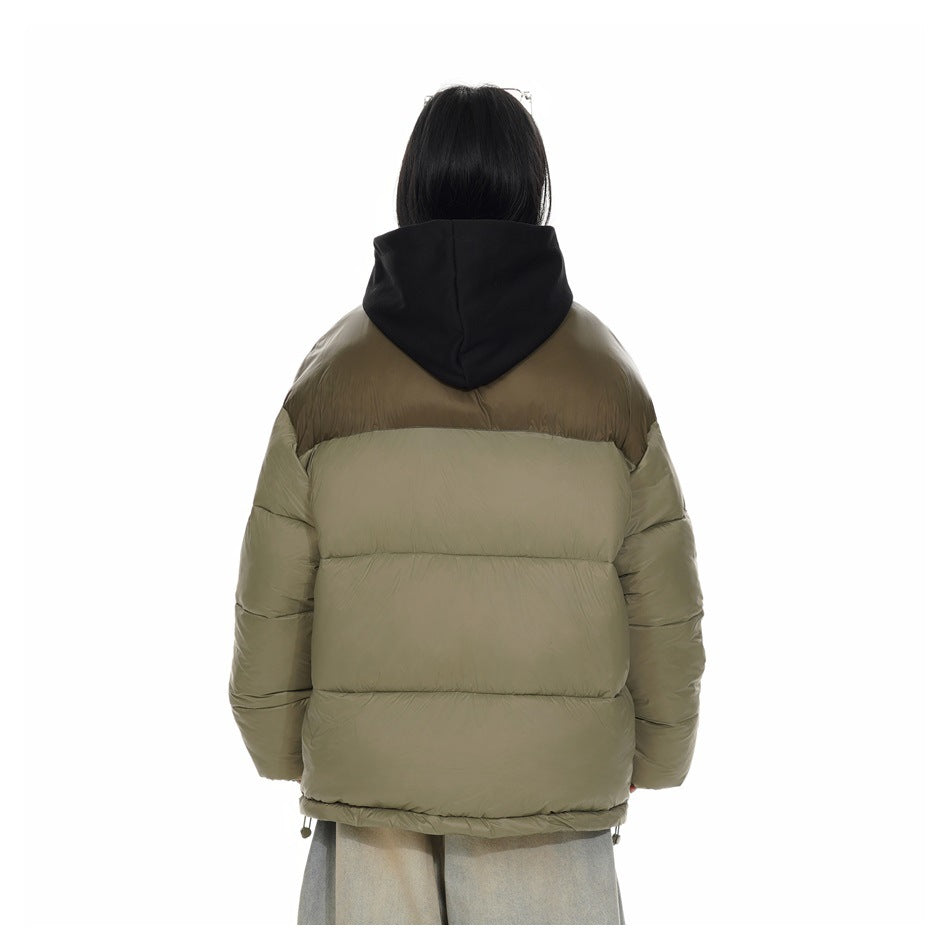 Back view of a model wearing an olive puffer jacket with a brown upper panel and black hood.