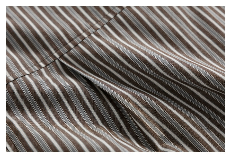 Close-up of striped shirt fabric gathered around a stitched seam.