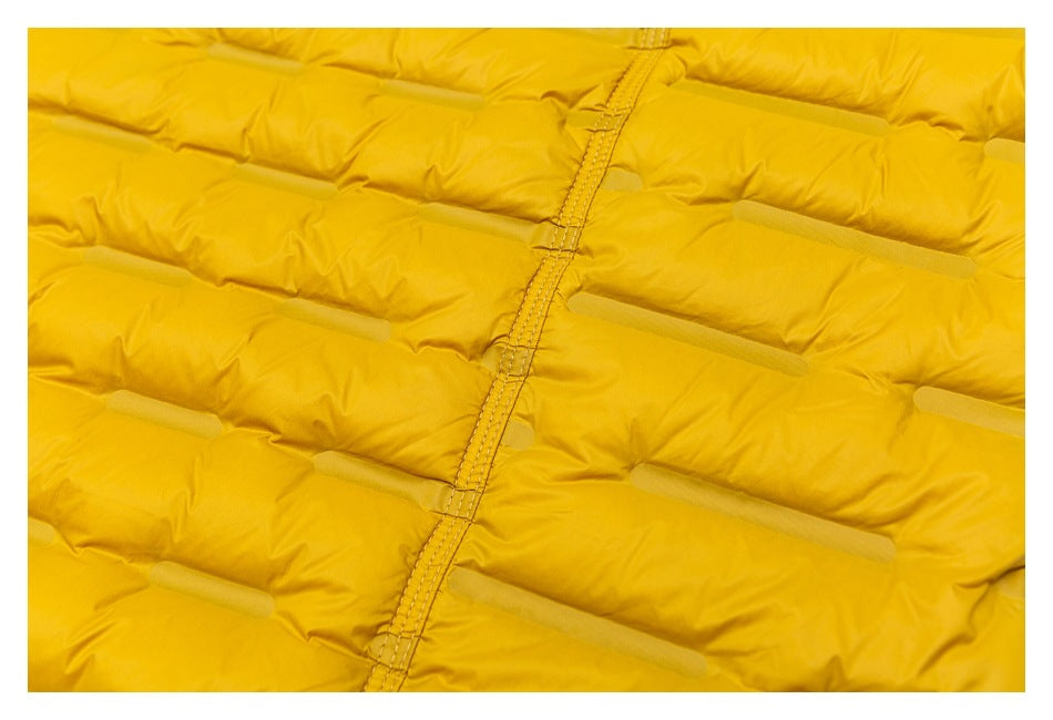 Close-up of the mustard-yellow jacket's quilted panels and central stitched seam.