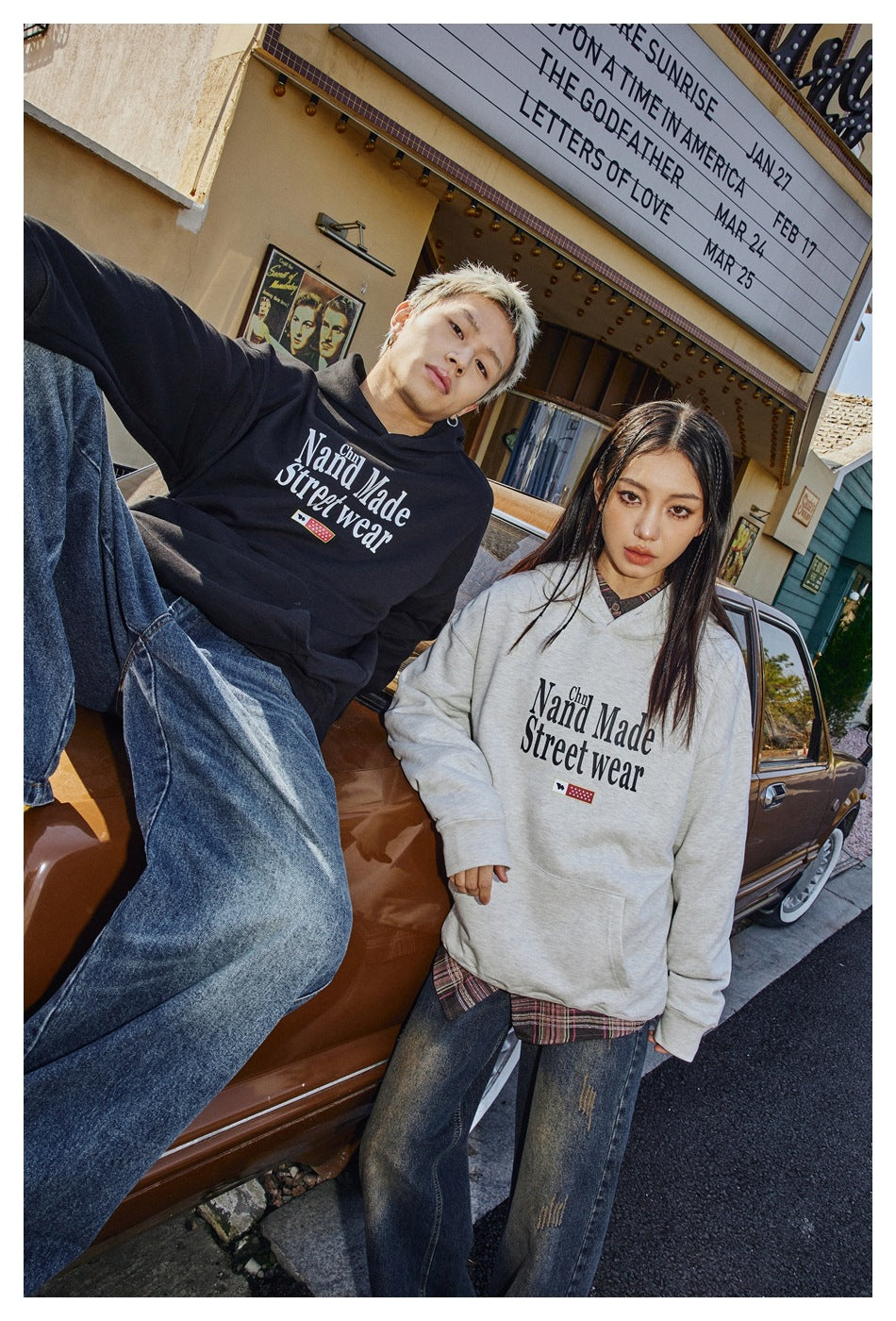A closer view of two models in black and light gray graphic hoodies with kangaroo pockets.