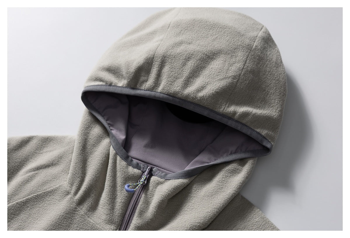 Close-up of a jacket hood with a light gray outer surface, dark lining, and zip fastening.