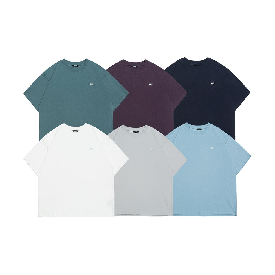 Six short-sleeve crew-neck T-shirts laid flat in teal, plum, navy, white, gray, and light blue.