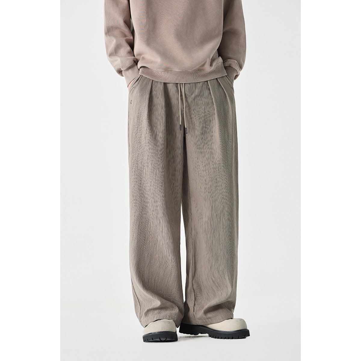 Front view of taupe wide-leg pants with a drawstring waist, worn with a matching sweatshirt.