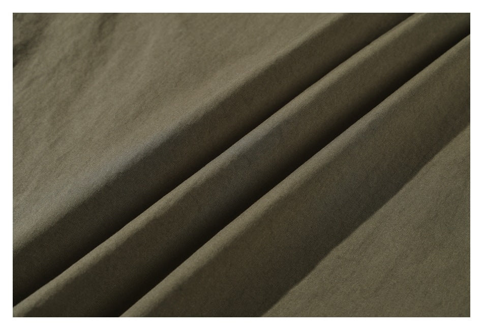 Extreme close-up of olive fabric draped in folds.