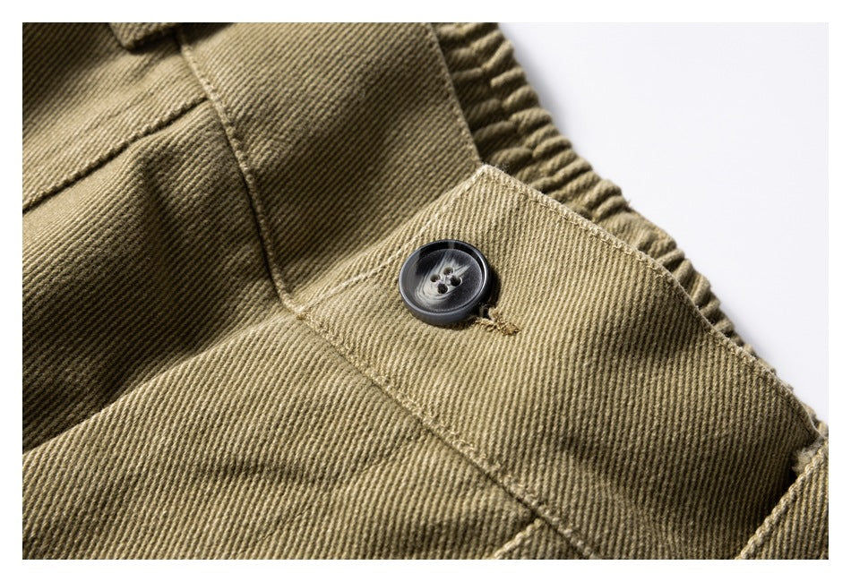 Close-up of the khaki trouser waistband with a dark button, belt loop, and stitching.