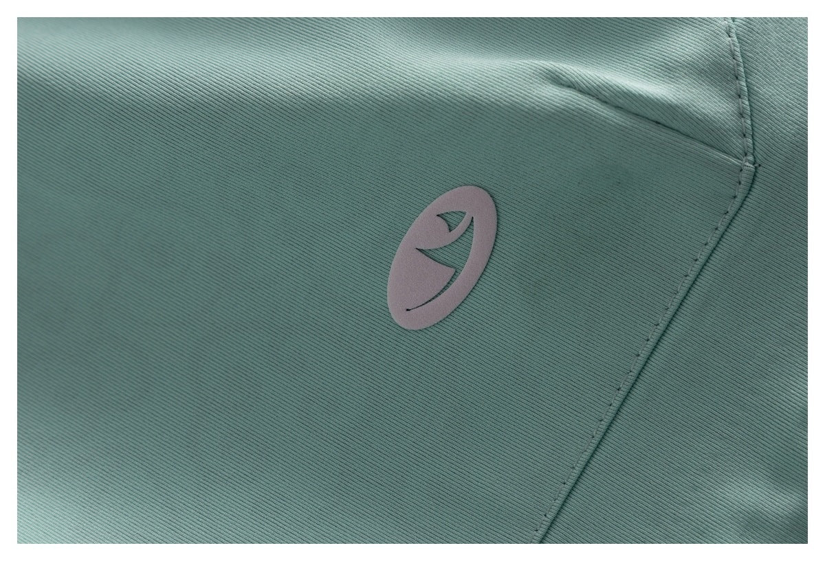 Close-up of a small oval emblem on the pale mint jacket fabric.