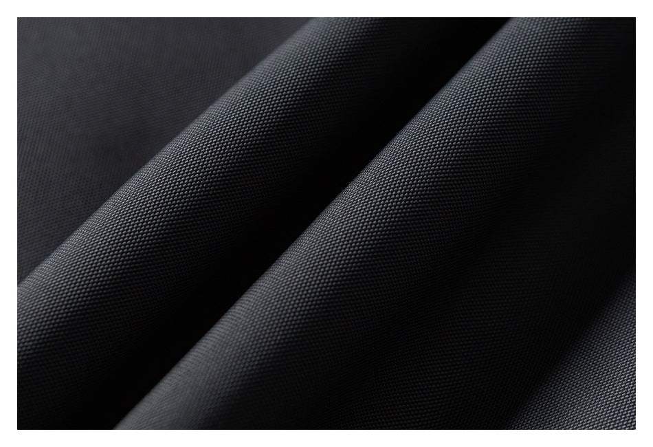 Macro view of the textured dark charcoal garment fabric.